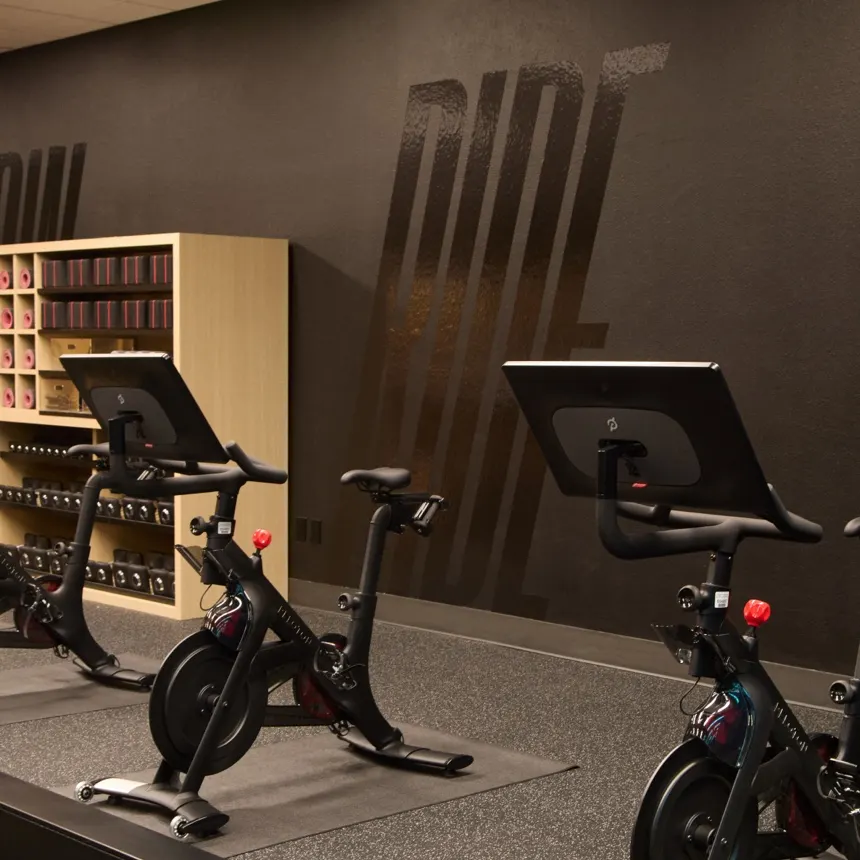 An image of a Peloton branded gym featuring Peloton Bikes