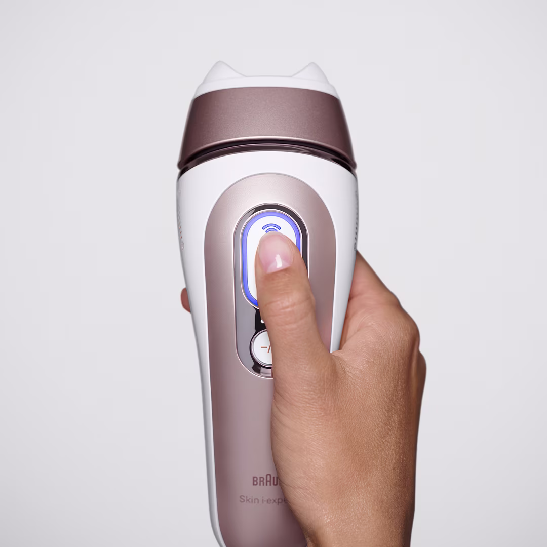 Vue de face du Braun Skin i·expert avec une tête intelligente flexible, dans la main d’une femme appuyant sur le bouton de démarrage. Vue de face du Braun Skin i·expert avec une tête intelligente flexible, dans la main d’une femme appuyant sur le bouton de démarrage.