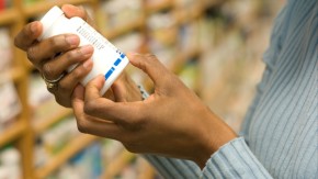 Closeup of person reading label on supplement bottle