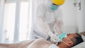 Äldre man som ligger i sjukhussäng på grund av coronavirusinfektion