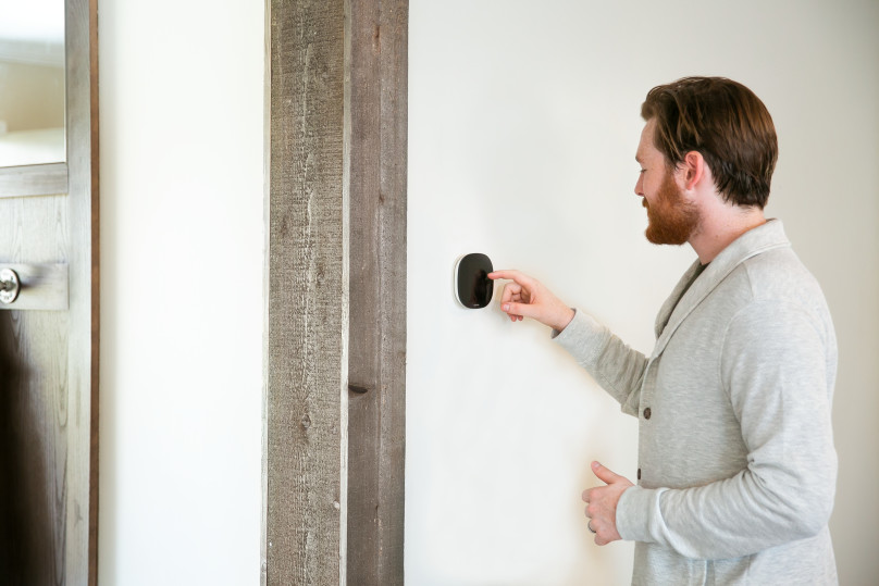 Man adjusting the temperature on the ecobee thermostate in a manufactured home