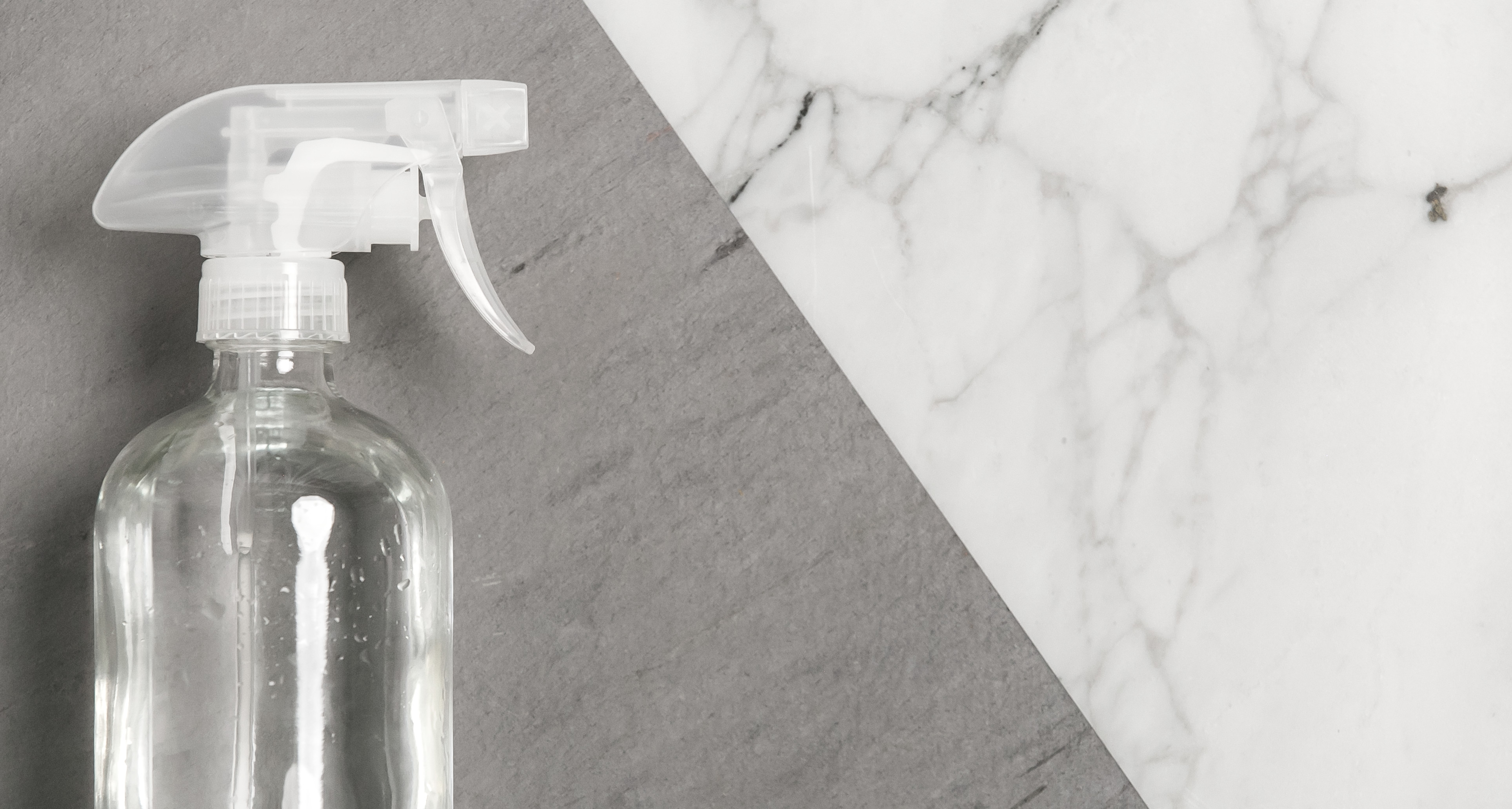 glass cleaning bottle laying on a marble countertop