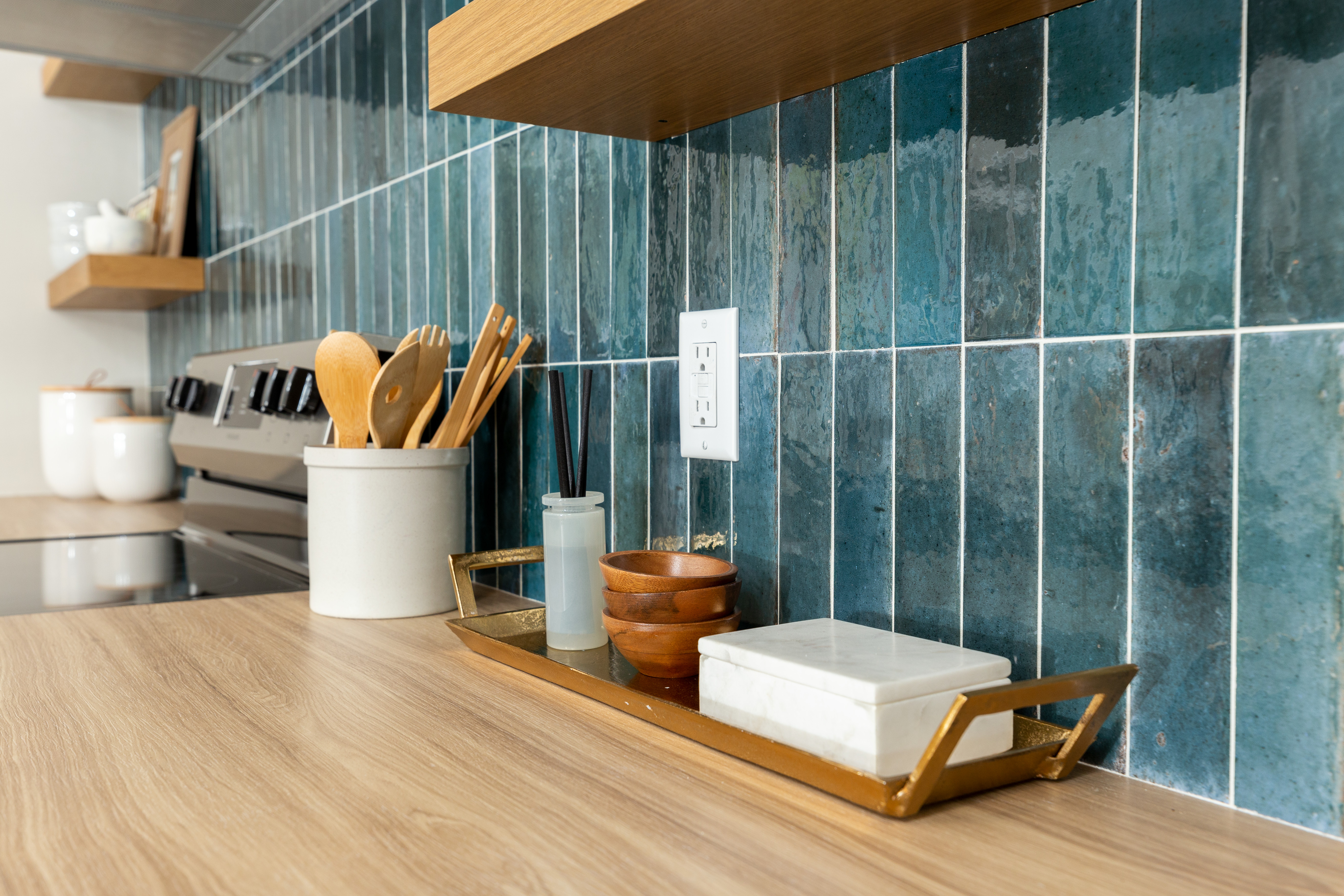 Blue, vertical backsplash in a kitchen with wooden countertop