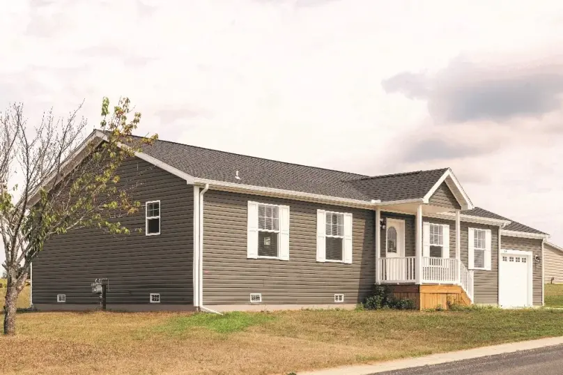 Brown exterior of manufactured home with white trim and a small front porch.