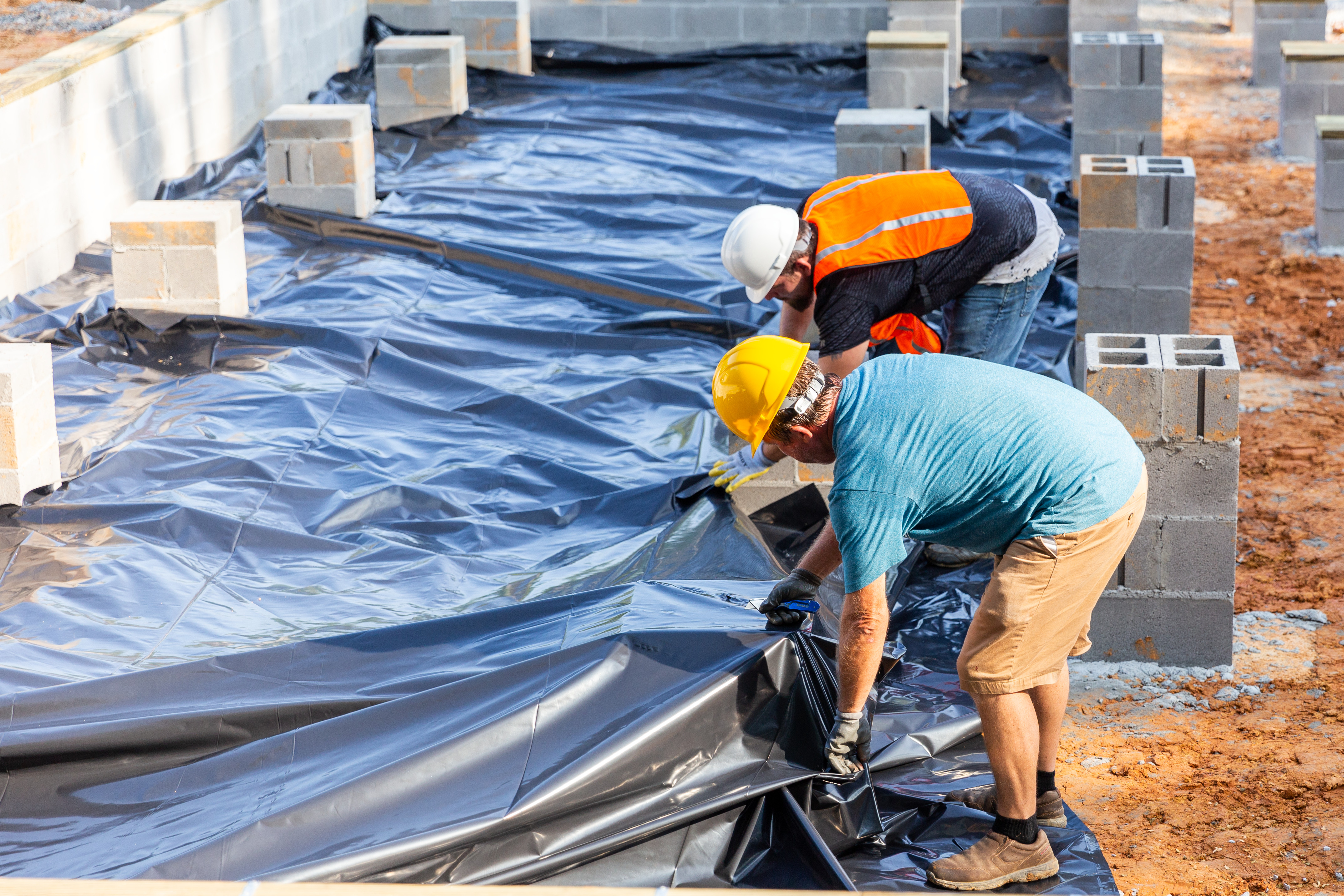 Manufactured home concreate footers being placed with a vapor barrier 