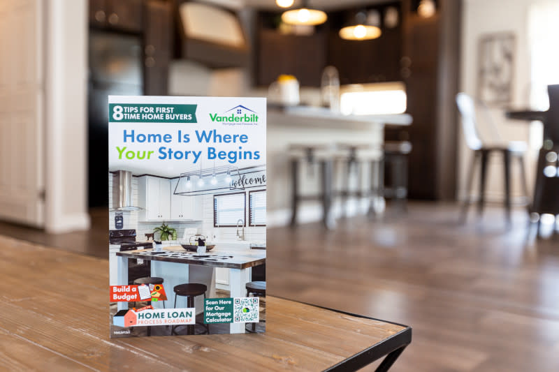 The home loan guide stands on an end table with a kitchen in the background.