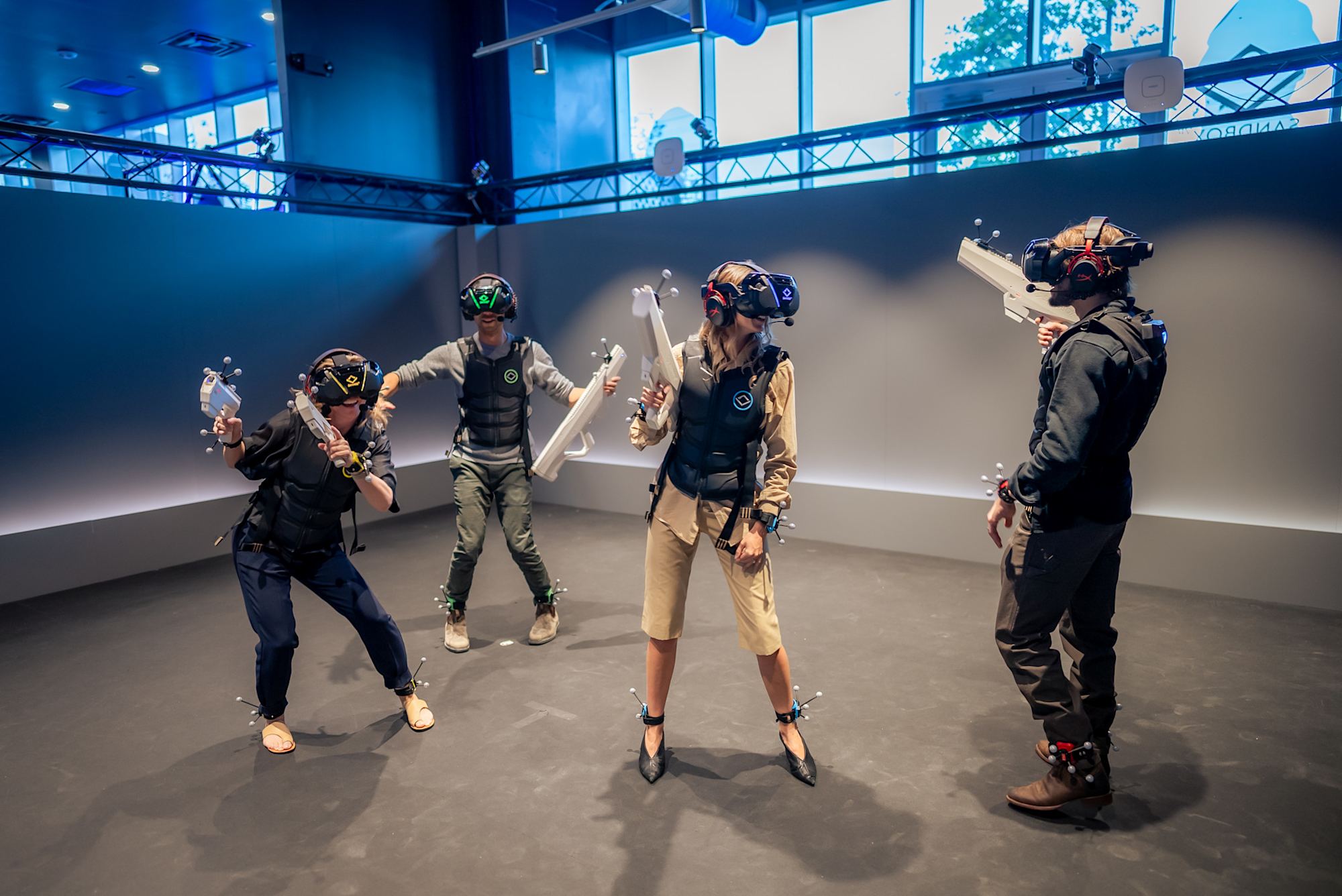 Team mit VR-Headsets und Trackern arbeitet auf der Spielfläche zusammen