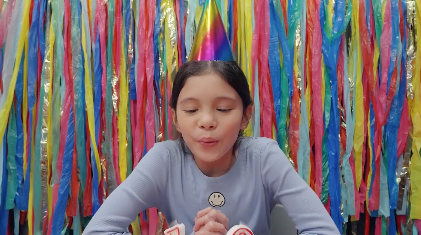 Young girl blowing out her birthday candles at a birthday party at Sandbox VR