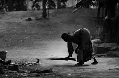 A woman in rural India cleaning the floor in front of their house, the light was mostly from behind the subject lighting up the dust and leaving her as an almost silhouette. 