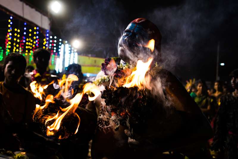 Shot during Kulasai Dassara festival celebrations in Kulasekarapattinam in Tamil Nadu. A man dancing with two lit wooden logs.