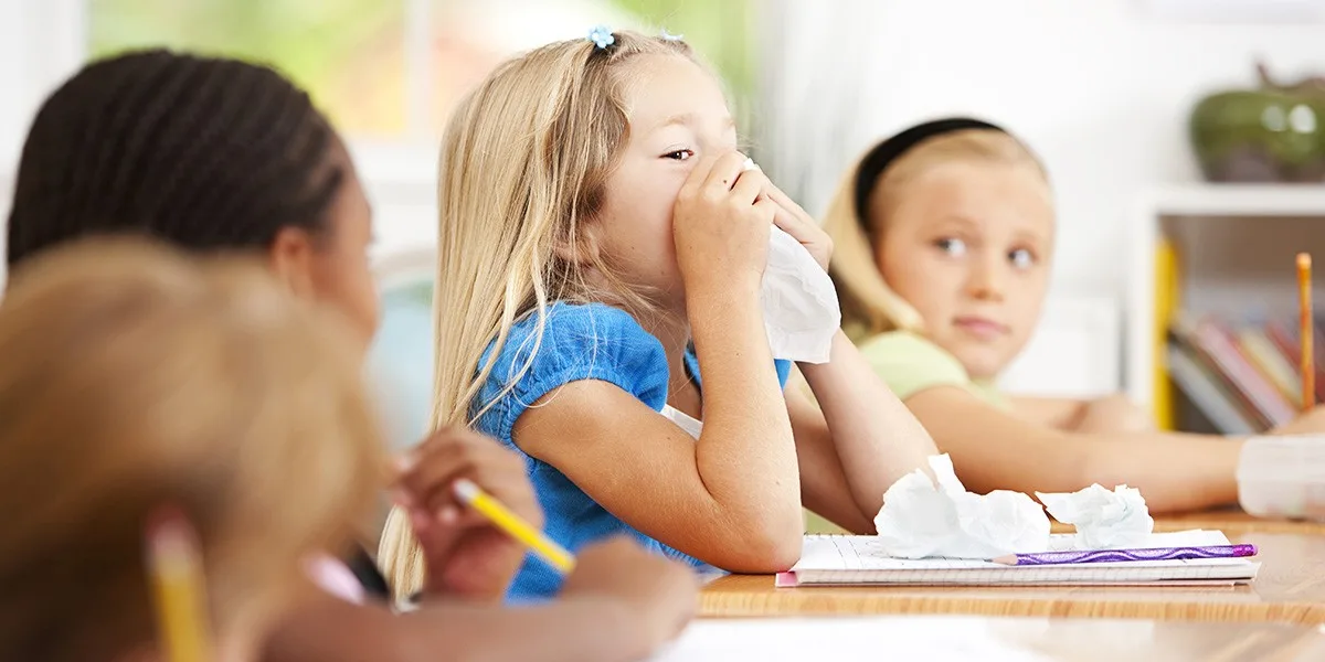 Staying Healthy: Navigating Peak Cold and Flu Season in Schools - Child Blowing Nose in Classroom