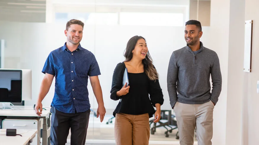 Three people walking in an office