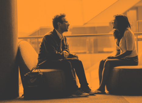 Two personas at the office, talking with each other. 