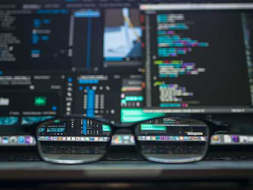 glasses in front of code on a computer