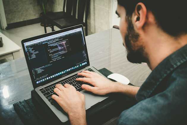 man coding on a laptop