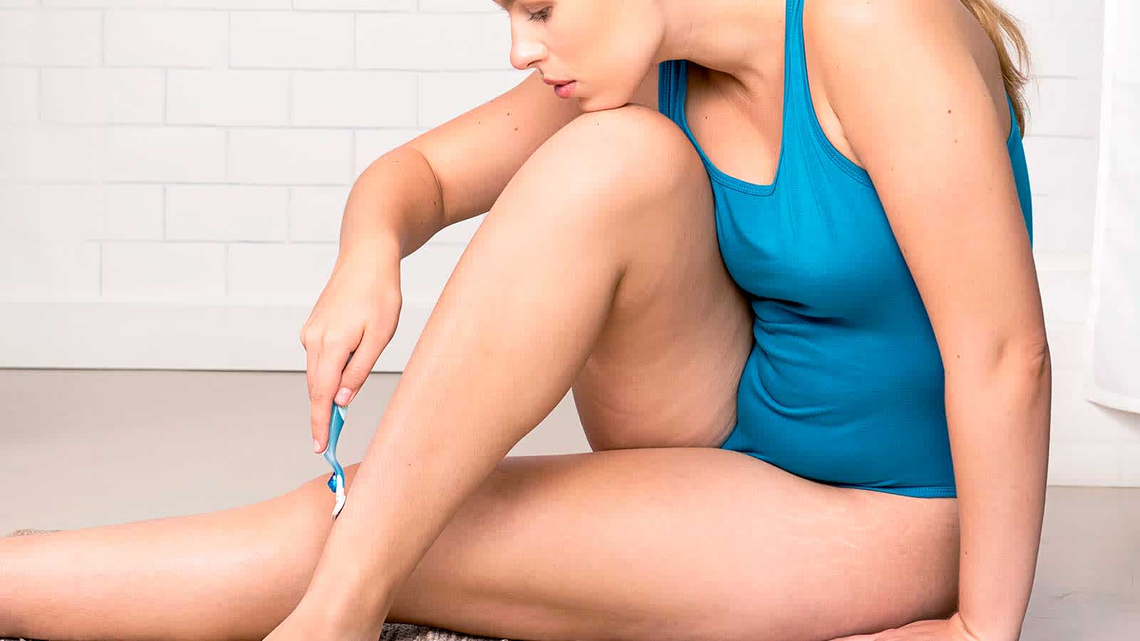 Femme s’épilant délicatement les jambes avec un rasoir Gilette Venus