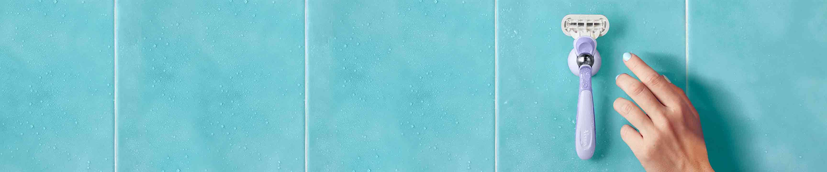 Rasoir rechargeable posé sur le support de douche dans la salle de bain