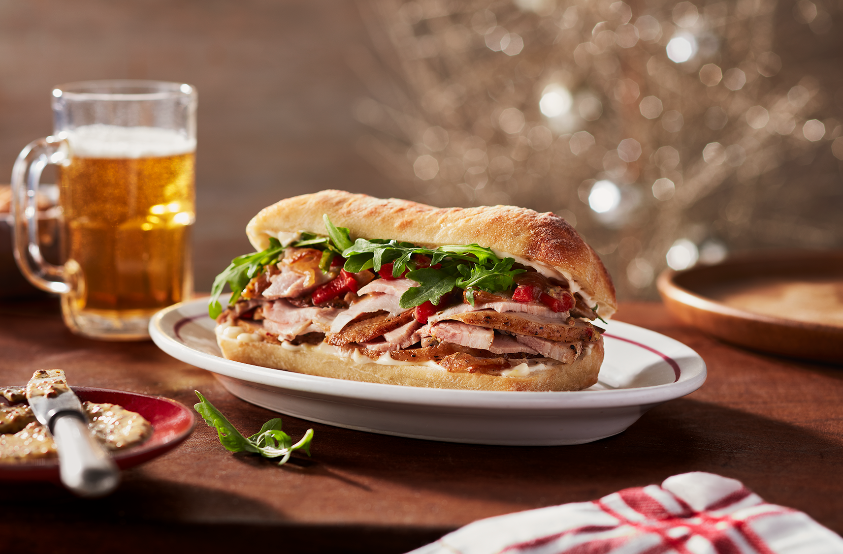 A delicious toasted sandwich filled with slices of porchetta, roasted red peppers and arugula.