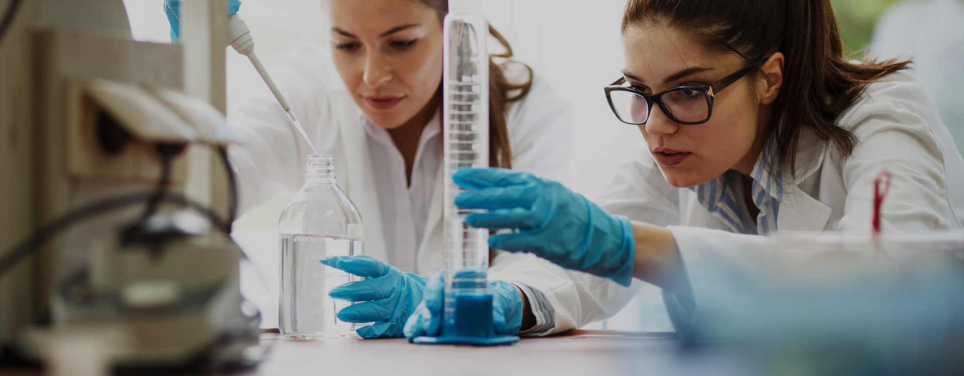 Reaktifleri ile birlikte laboratuarında çalışan genç kadın bilim adamları