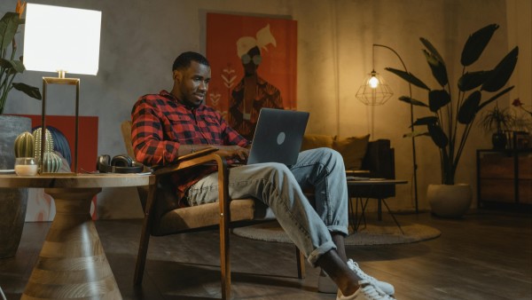 Man sitting on a chair while using a MacBook