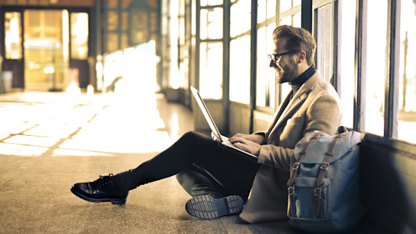 Man with a laptop sitting on the floor