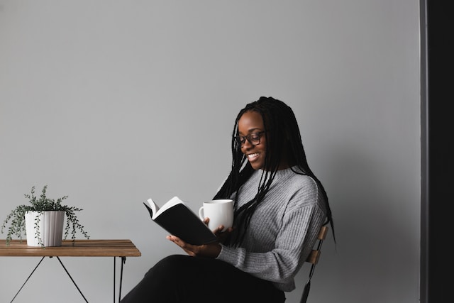 woman in white and black stripe long sleeve shirt sitting on chair
