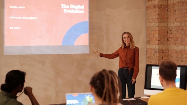 Woman in a red long sleeve shirt doing a presentation