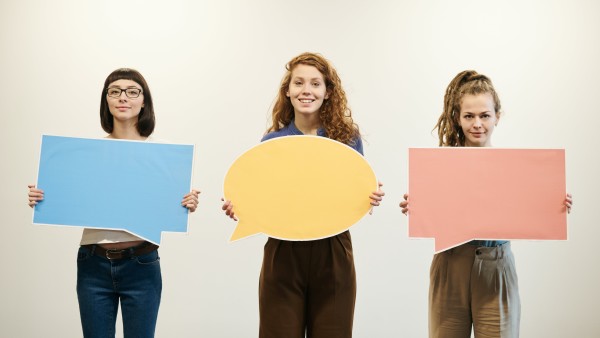 Women holding bubble text cards
