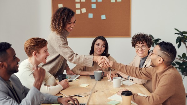 Cheerful colleagues shaking each other's hands