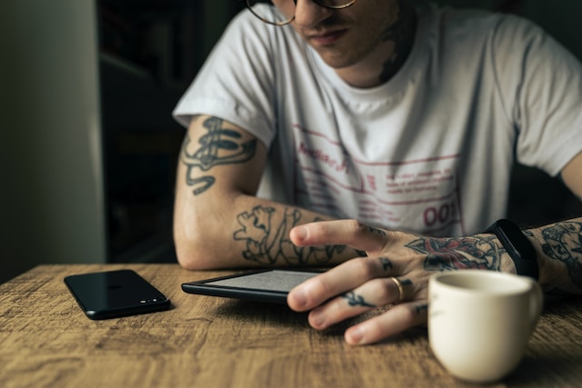 A man at a desk with a Kindle