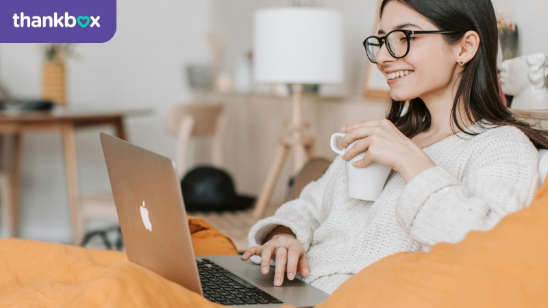 Woman having coffee while using a laptop