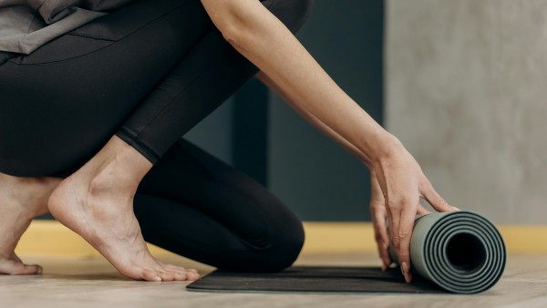 Woman unrolling a yoga mat