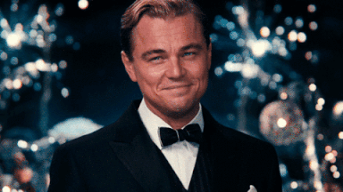 GIF of Leonardo di Caprio at an awards dinner raising a champagne glass 