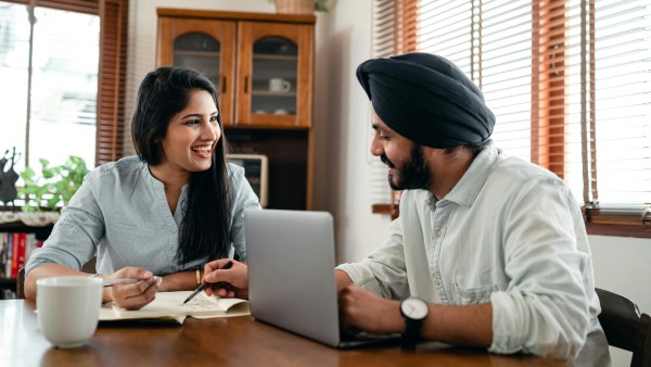 Cheerful couple discussing business at home