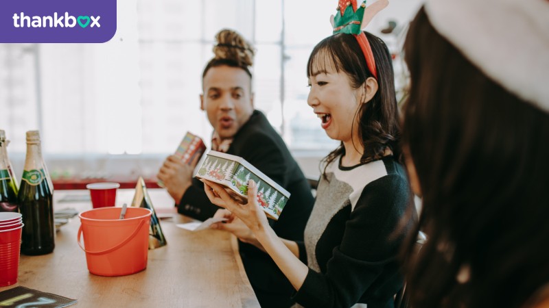 Excited Asian woman opening a present