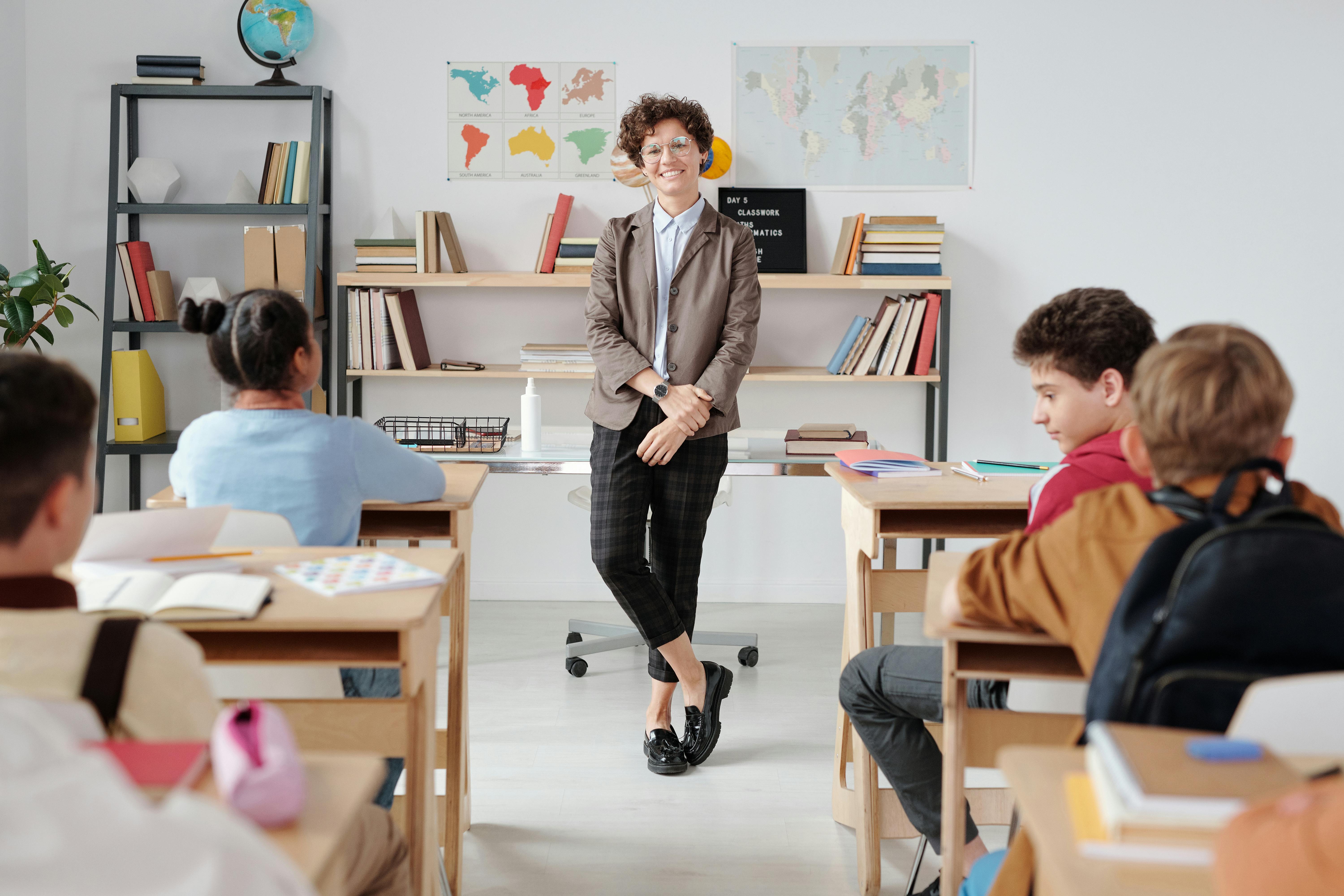 A Teacher Standing in the Classroom With Students