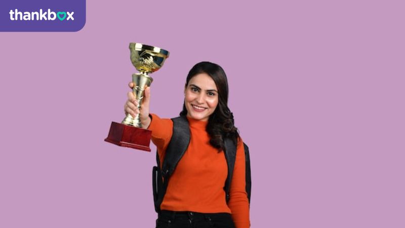 An image of the an Employee of the Month winner with trophy