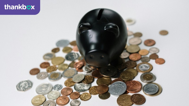 A Black Piggy Bank in the Middle of Coins
