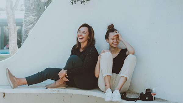 Laughing Women Sitting on a White Bench