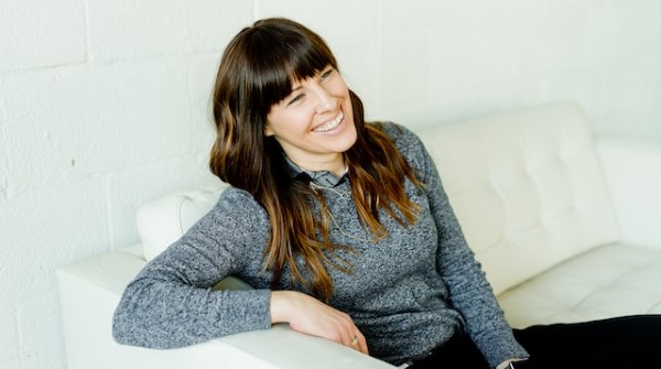 woman in gray sweater sitting on white chair