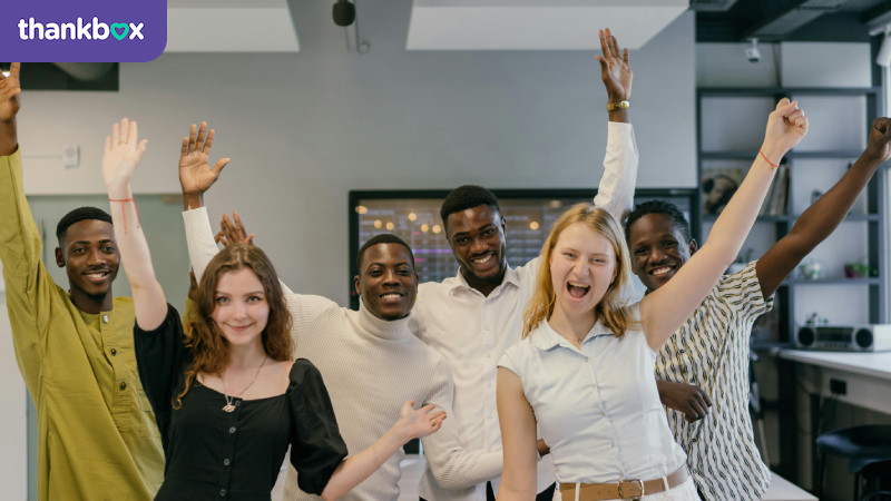 Employees raising their hands while smiling