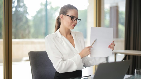 Confident businesswoman pointing at a list of paper