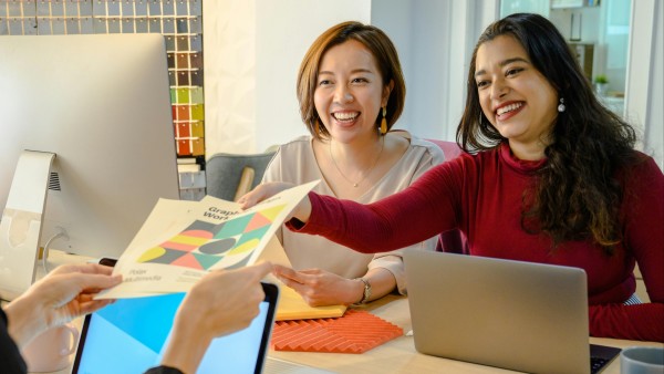 Cheerful women handing a report