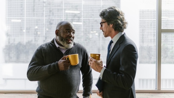 Businessmen Holding Coffee while Having Conversation
