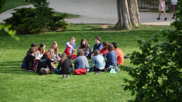 A group of people sitting on grass in a park