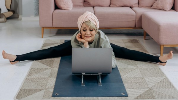 Woman stretching while using a laptop