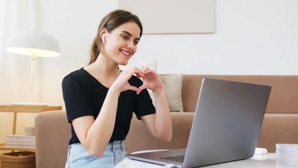 Woman making heart with hands while in a video call