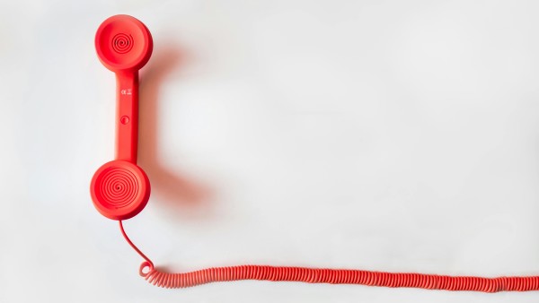 Red telephone on a white surface