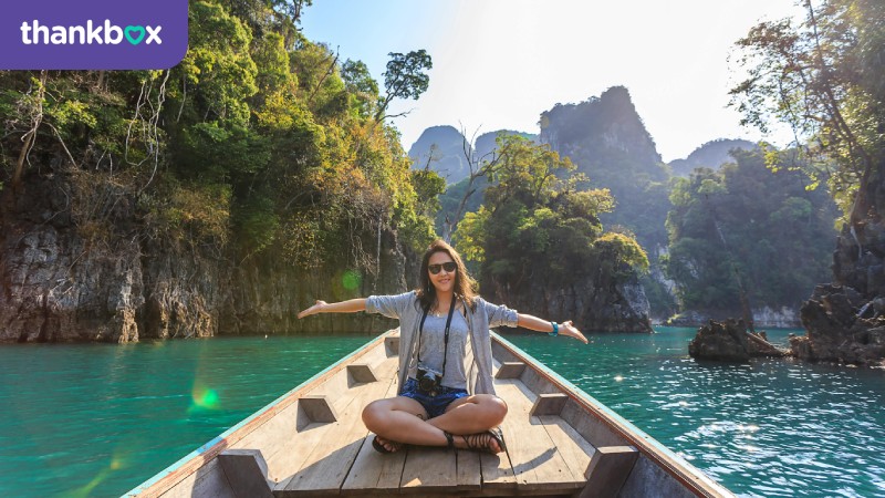 Woman sitting on a boat spreading her arms