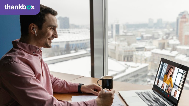 Side view of man having an online video call with coworkers
